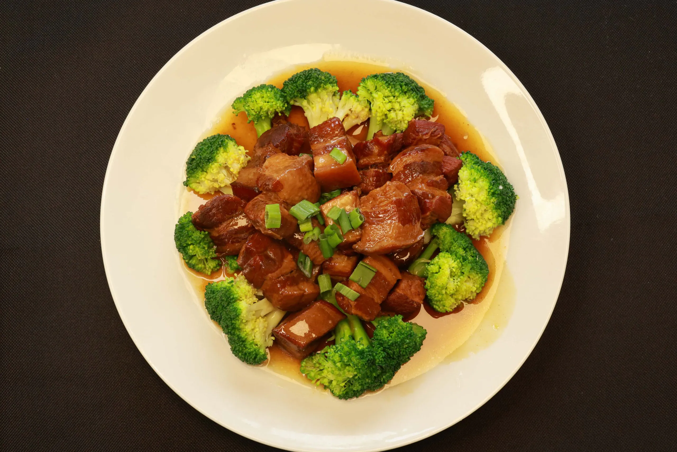 Tender braised pork cubes with glossy sauce and broccoli at Bao House, a Chinese Restaurant in Stillwater